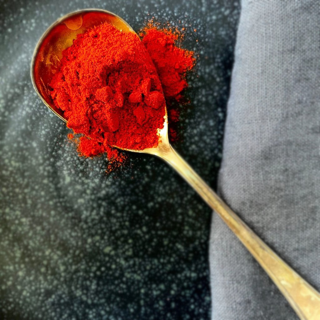 rote Paprika edelsüß Pulver auf einem großen Löffel